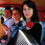 Le trio HerMaNa en photo dans une vieille voiture rouge